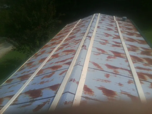 Rusted metal roof panels with new wood purlins before replacement — Storm Damage Roof Repair in Providence by Roofing Brothers